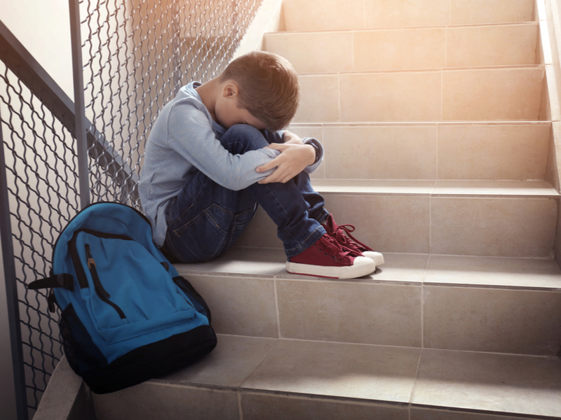 Elev pe scări, la școală, bătut, agresat, bullying, violență, copil cu ghiozdan