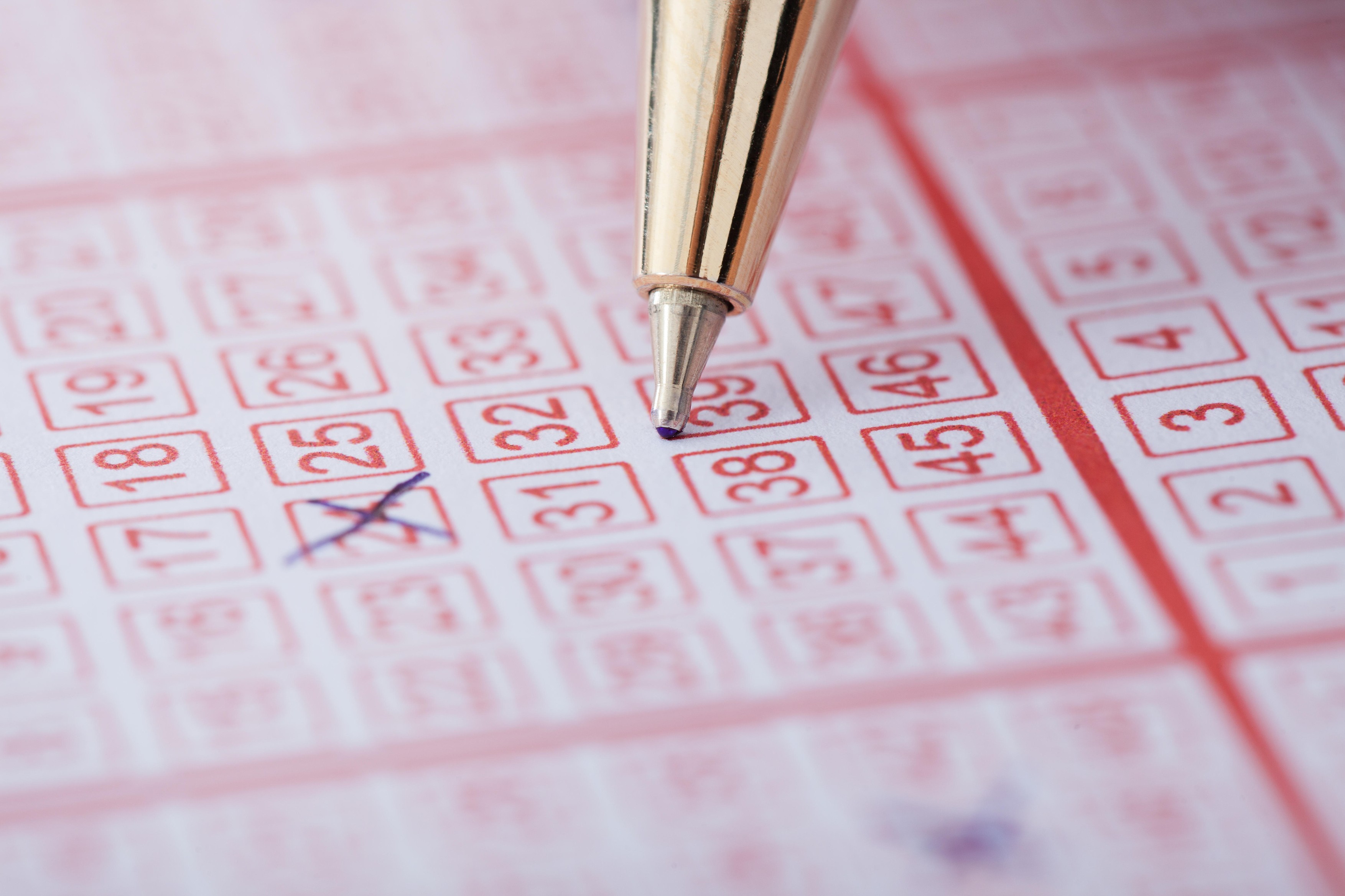 Closeup of pen marking numbers on lottery ticket