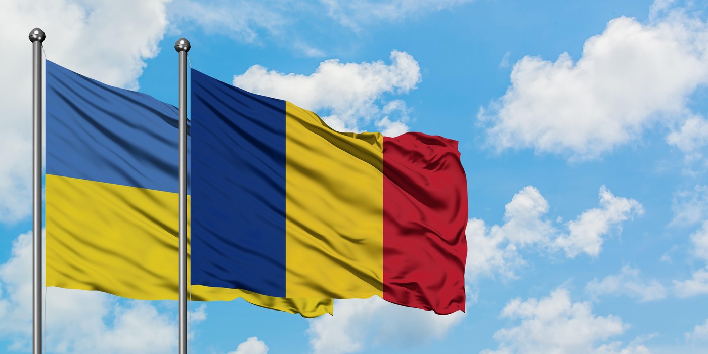 Ukraine and Romania flag waving in the wind against white cloudy blue sky together. Diplomacy concept, international relations.