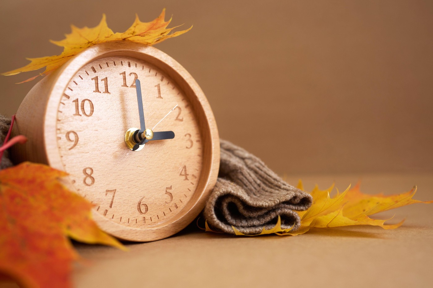 Wooden clock with autumn leaves indicating time change